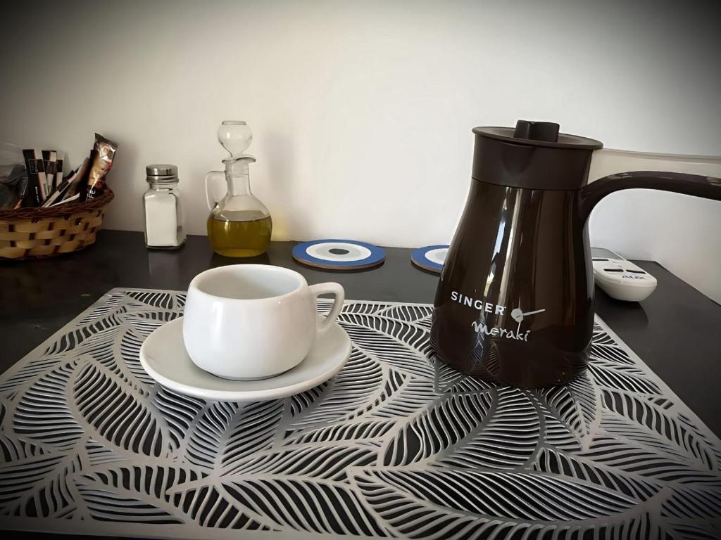 una cafetera y una taza sobre una mesa en Centrally Apartment - Xanthi, en Xanthi