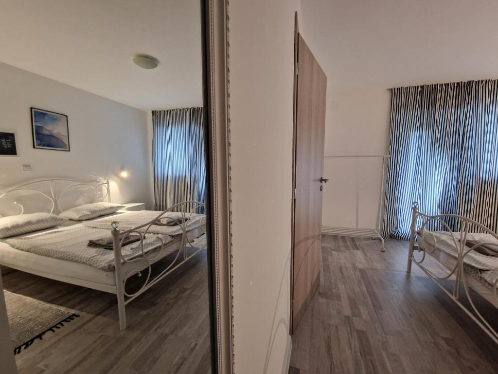Apartman Castle في Tušilović: مرآة تعكس غرفة نوم مع سرير فيها