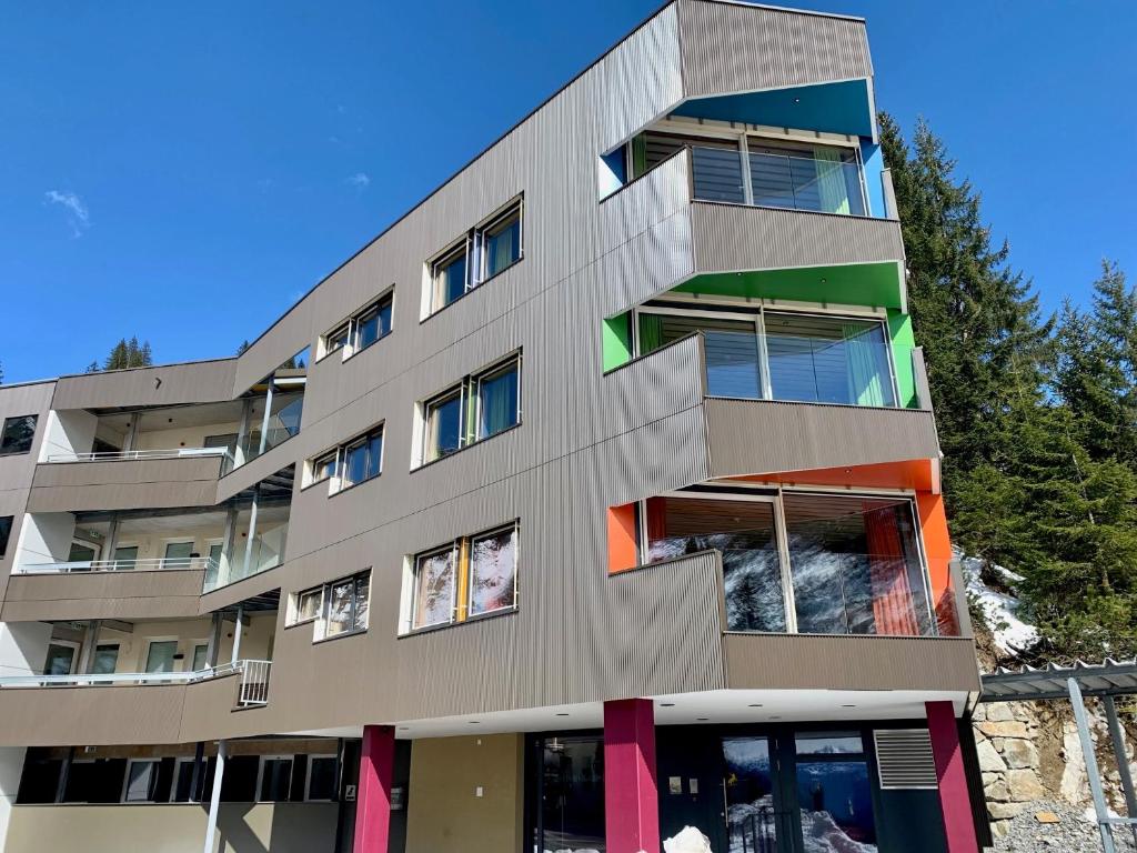 un immeuble d'appartements avec des fenêtres colorées sur son côté dans l'établissement Wohlfühlhotel Hubertushof, à Stuben am Arlberg