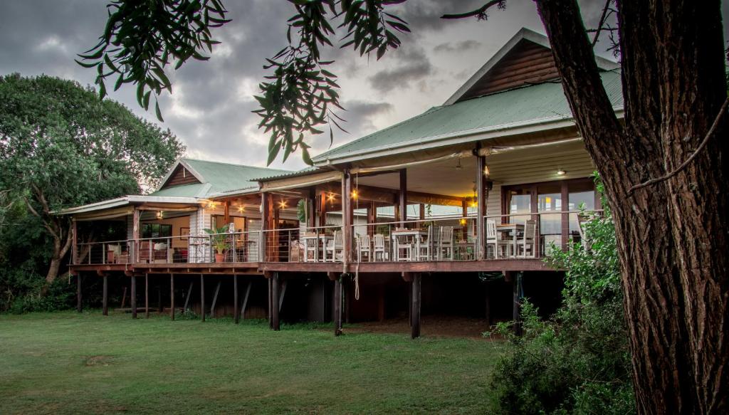 a large house with a large deck with chairs at Hluhluwe River Lodge in Hluhluwe