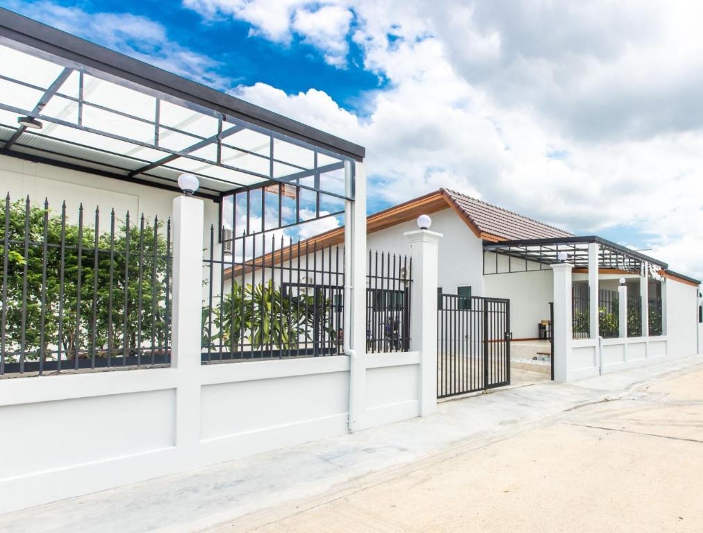 a white house with a gate and fence at Tonsoi Hathairat in Ban Tao Pun