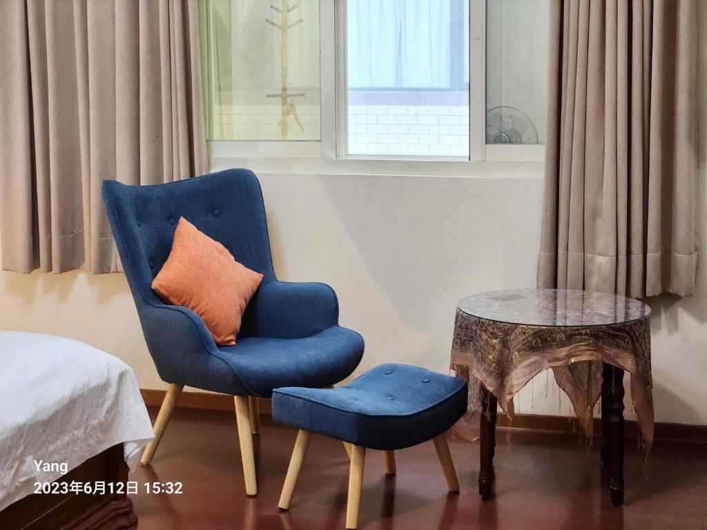 a blue chair with an orange pillow and a table at East of Love Homestay in Hualien City
