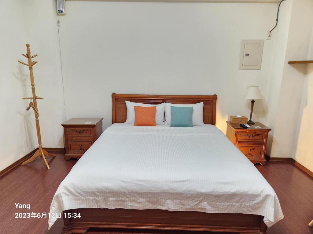 a bedroom with a large bed with two night stands at East of Love Homestay in Hualien City