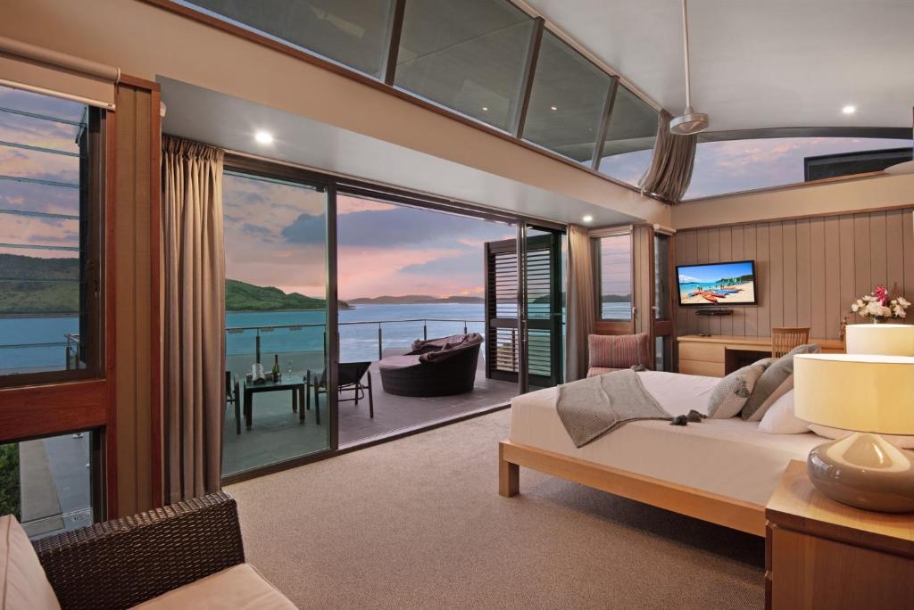 a living room with a bed and a view of the ocean at Yacht Club 33 Serenity House Ocean Views 2 Buggies in Hamilton Island