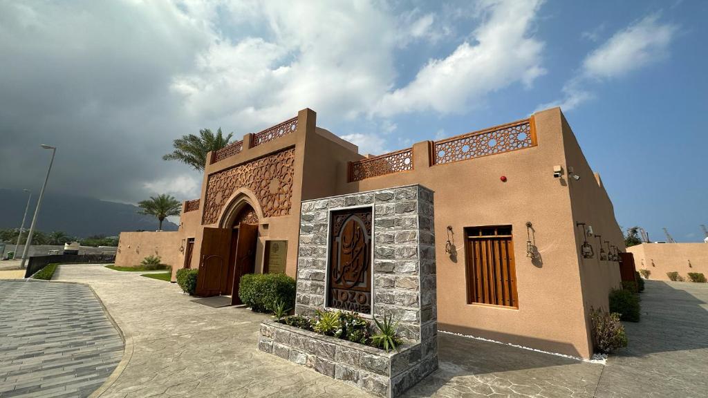 豪爾費坎的住宿－Nozol Al Rayaheen By Sharjah Collection，建筑的一侧有门