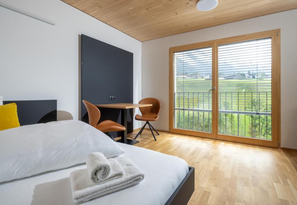 1 dormitorio con 1 cama y 1 mesa con sillas en Simotel en Aussersiggam