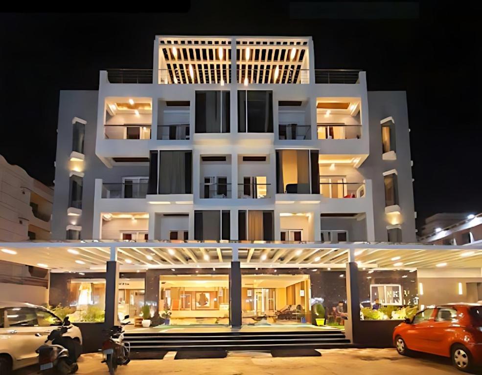a white building with cars parked in front of it at New Gitanjali Hotel, New Digha in Digha