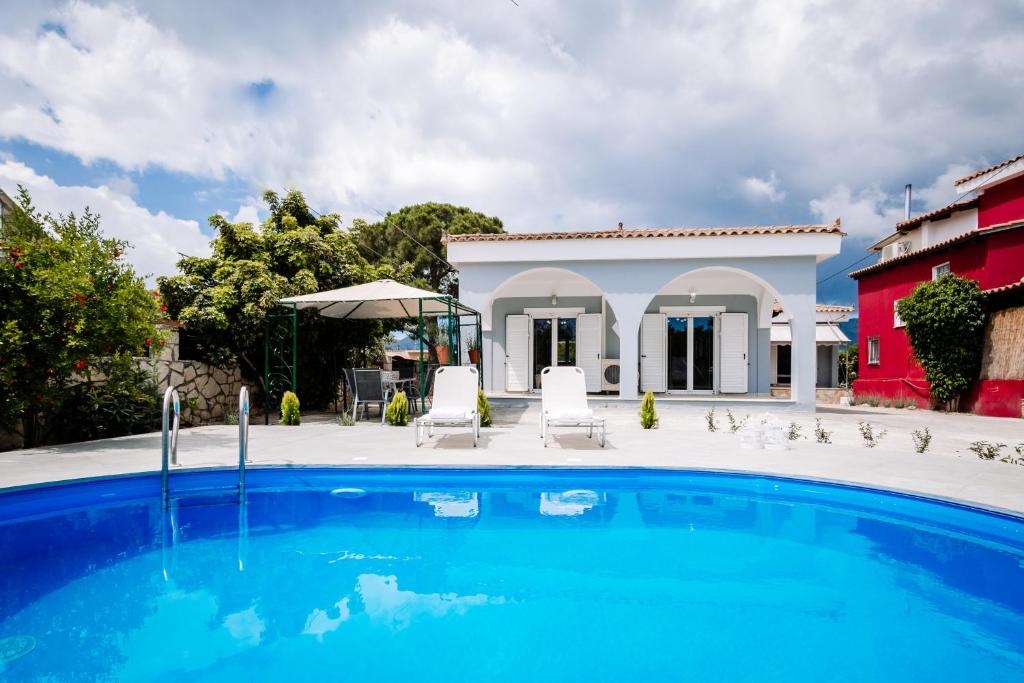 a swimming pool in front of a house at Rahes Villa with Private Pool in Zakynthos Town