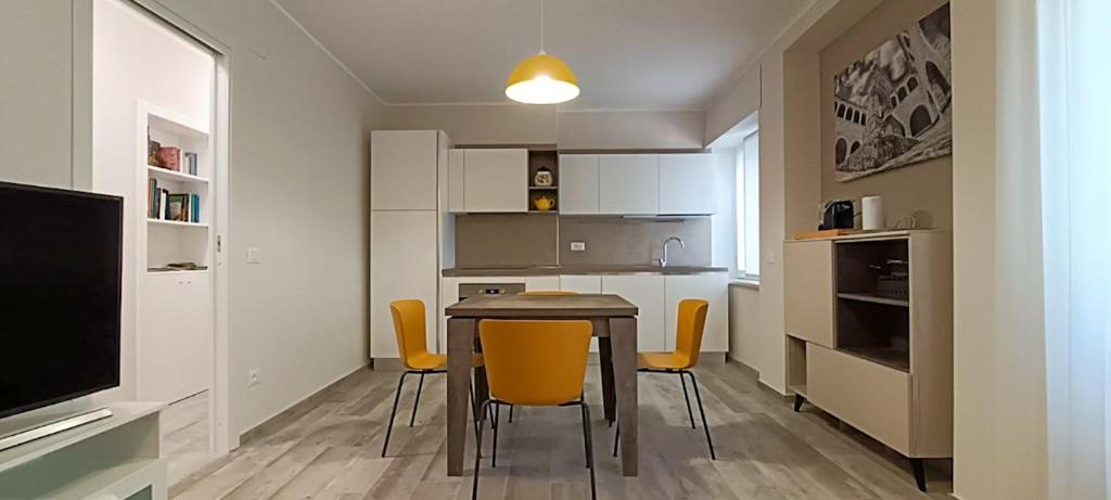 a small kitchen with a table and yellow chairs at Nice House in Atessa