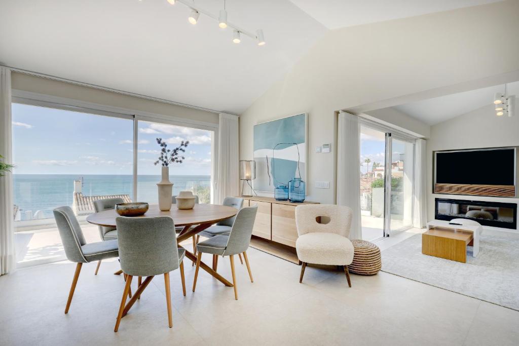 a dining room with a table and chairs and the ocean at Villa Endless Summer in Estepona