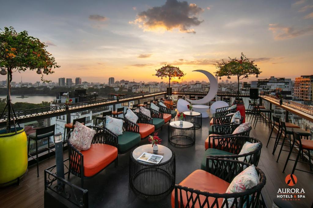 a rooftop bar with chairs and tables on a building at Aurora Premium - A Lifestyle Hotel in Hanoi