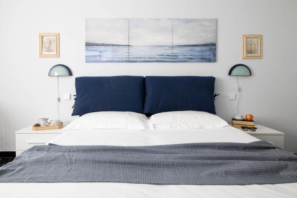 een slaapkamer met een bed met een blauw hoofdeinde bij Raffaello House in Sestri Levante