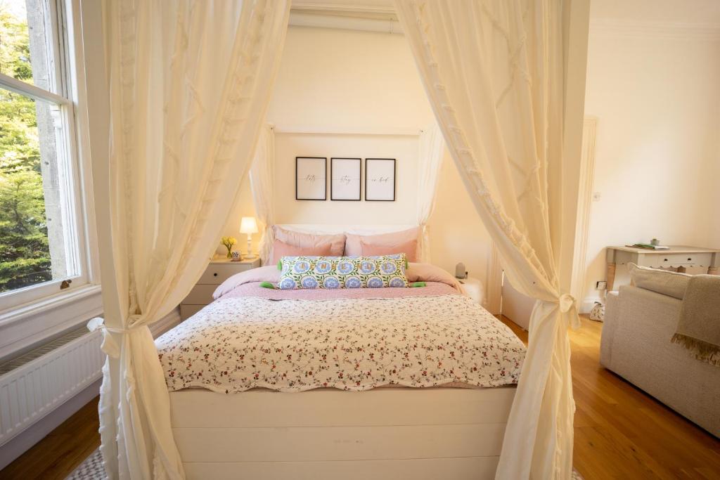 een slaapkamer met een hemelbed en een raam bij Studio Apartment in Central Bath in Bath