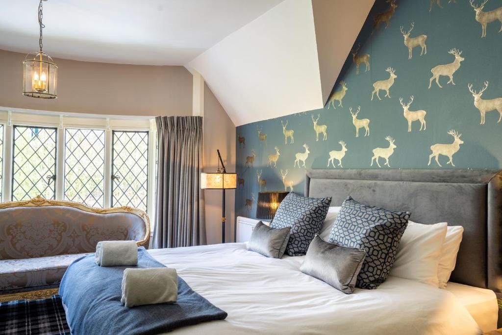 - une chambre avec un lit et un mur orné d'une fresque murale représentant des cerfs dans l'établissement Kettleburgh Chequers, à Kettleburgh