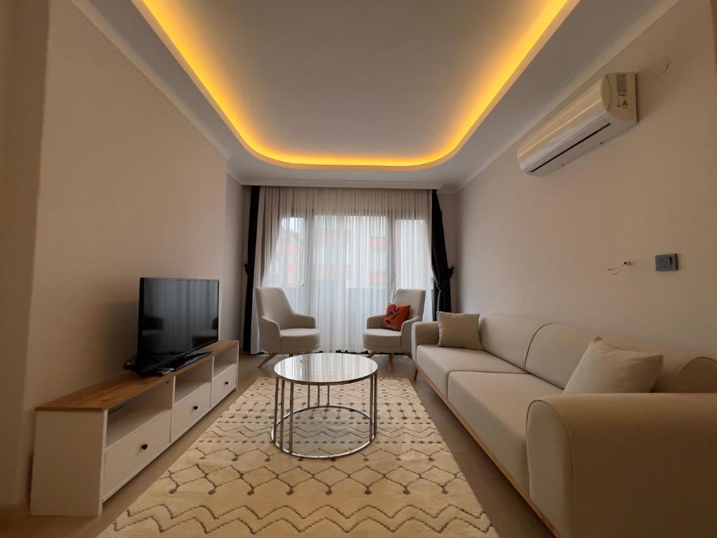 PURPLE VIP SUITE في طرابزون: غرفة معيشة مع أريكة وتلفزيون