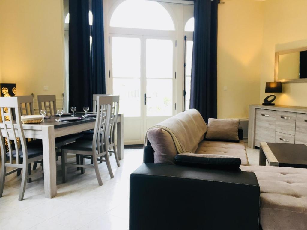 un salon avec une table et un canapé dans l'établissement Appartement rénové en rez-de-jardin, proche centre, 2 pièces, 4 pers., équipements modernes, Cabourg - FR-1-487-309, à Cabourg