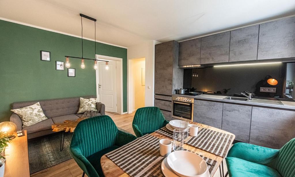 ein Wohnzimmer mit einem Sofa, einem Tisch und Stühlen in der Unterkunft Arbio I Cozy Apartment Augsburg-Göggingen in Augsburg