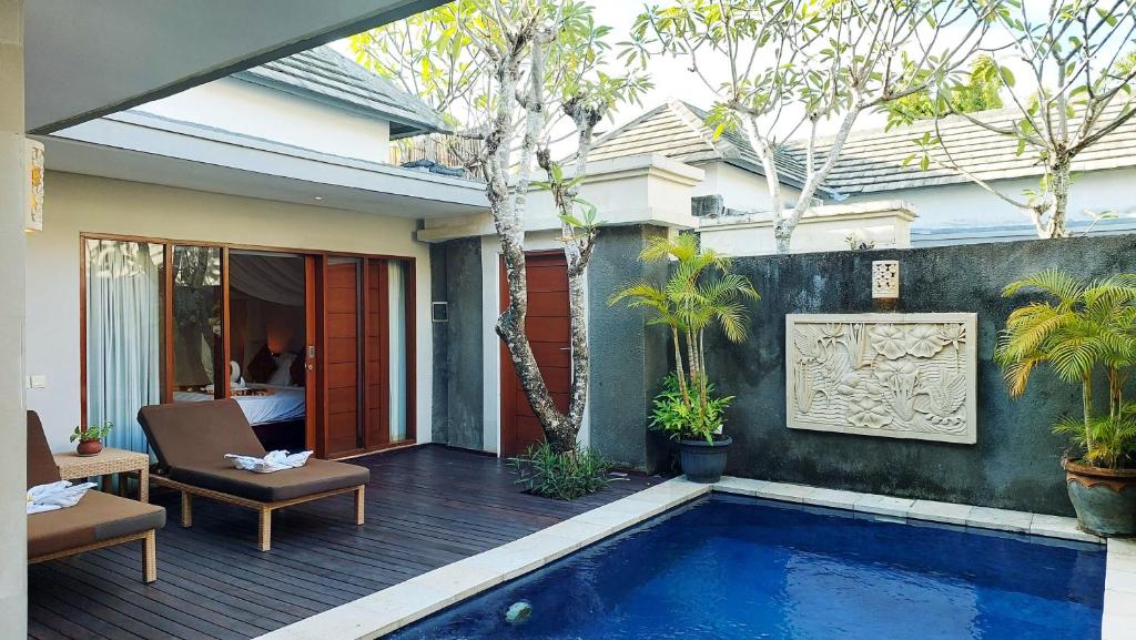 a patio with a swimming pool in a house at The Light Exclusive Villas and SPA - CHSE Certified in Seminyak