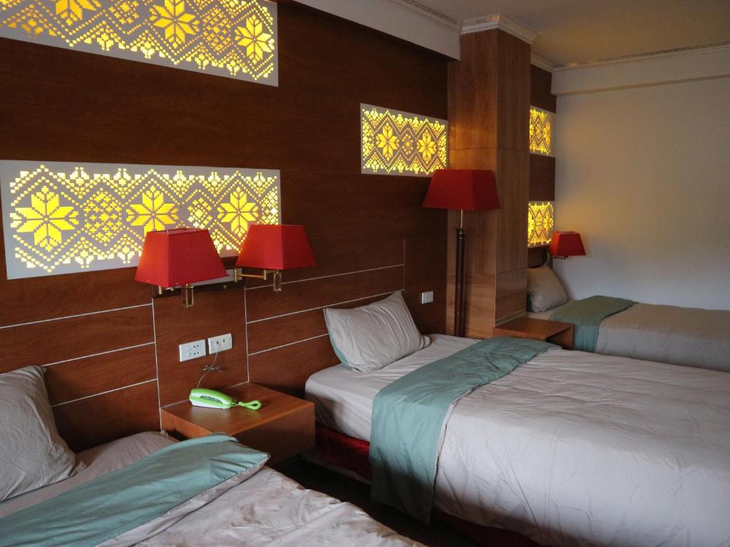 a hotel room with two beds and two windows at D Home Sapa 5 in Sapa