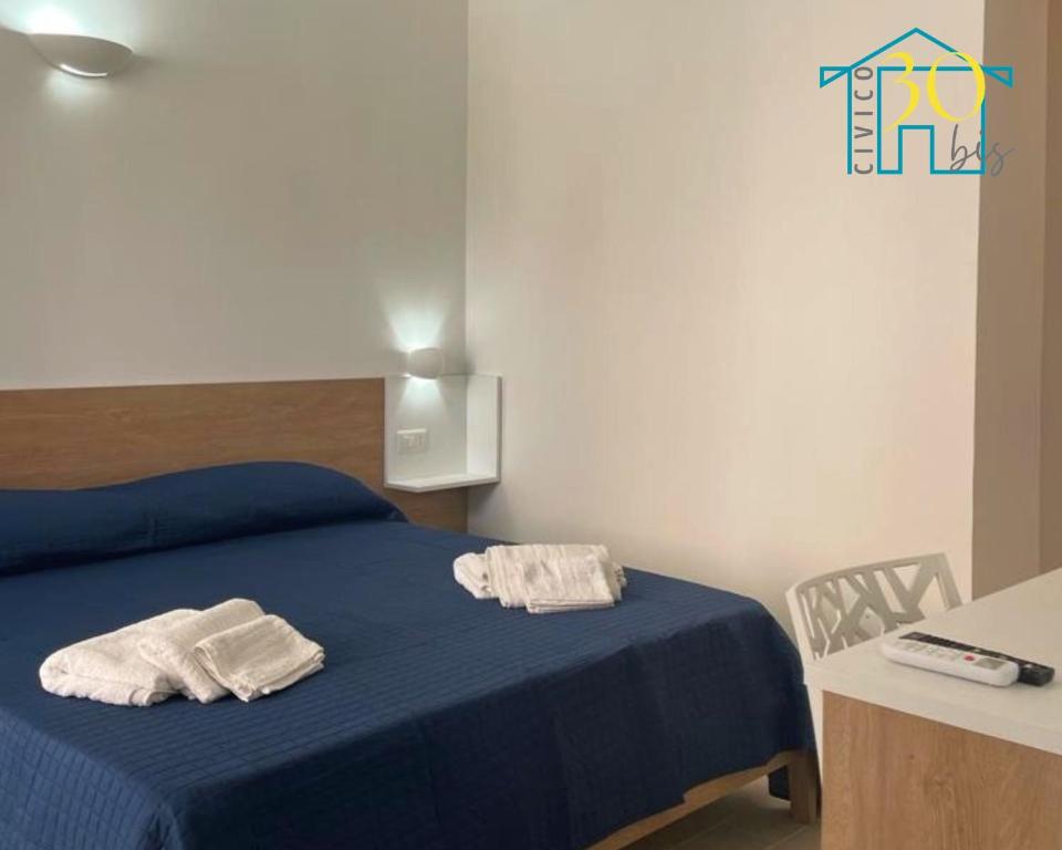- une chambre avec un lit bleu et 2 serviettes dans l'établissement CIVICO 30 bis, à Santa Domenica