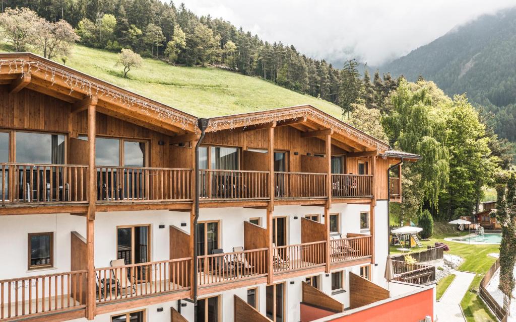 a large building with balconies and a mountain at Hotel Fernblick in Bressanone