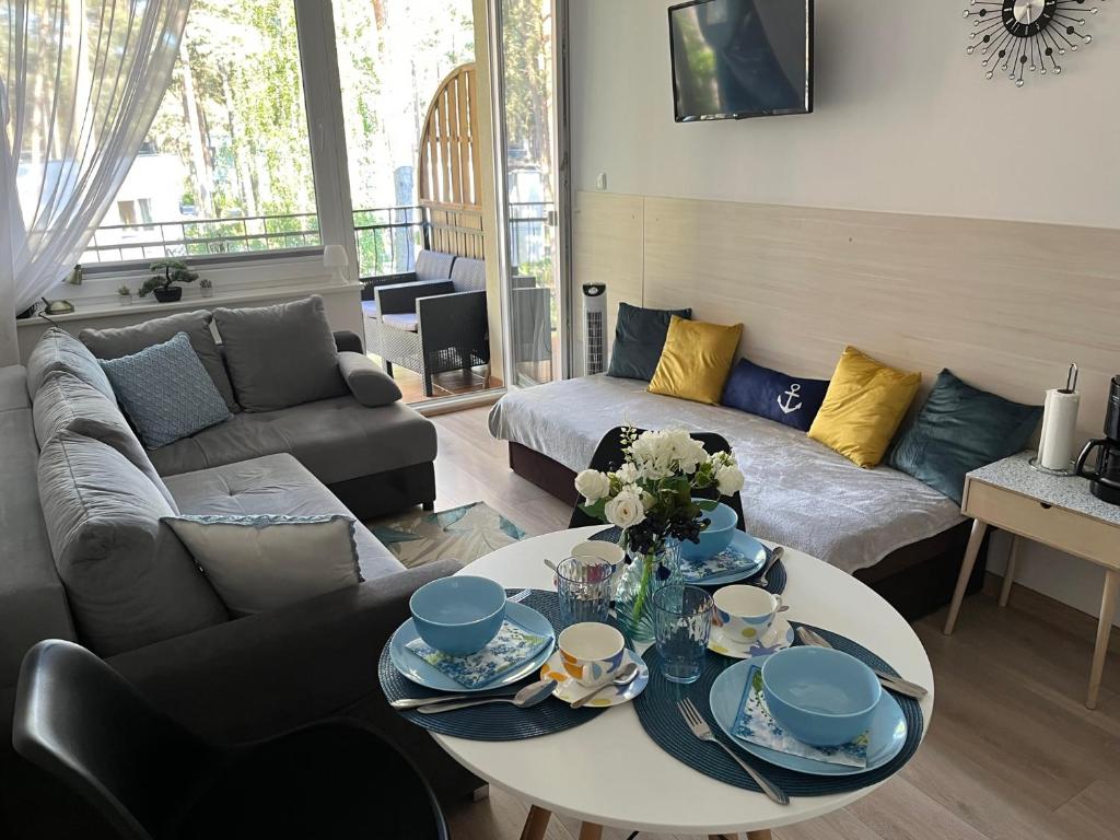 uma sala de estar com uma mesa e um sofá em APARTAMENT RELAX BLUE MARE em Łukęcin
