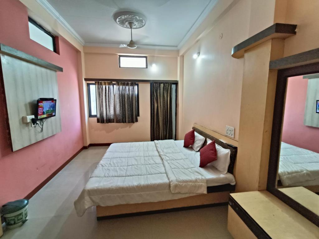 a bedroom with two beds and a tv in it at Hotel chaitanya in Maheshwar