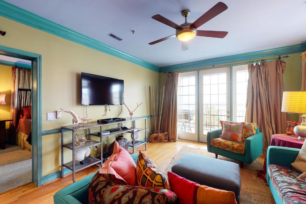 a living room with a couch and a ceiling fan at Pavilion Watch #2E in Folly Beach