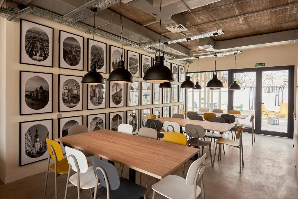 a dining room with tables and chairs and pictures on the wall at Hostelfly in Madrid