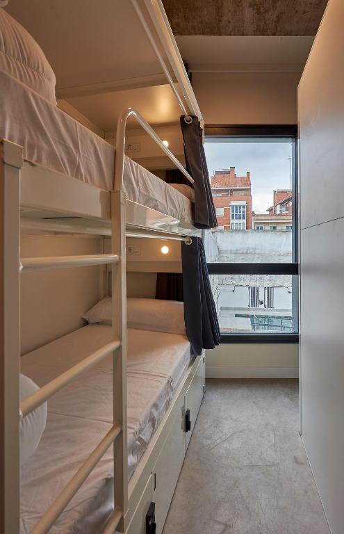 a room with bunk beds and a large window at Hostelfly in Madrid