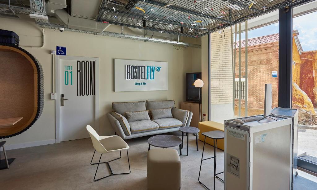 Hostelfly في مدريد: غرفة معيشة مع أريكة وطاولة وكراسي