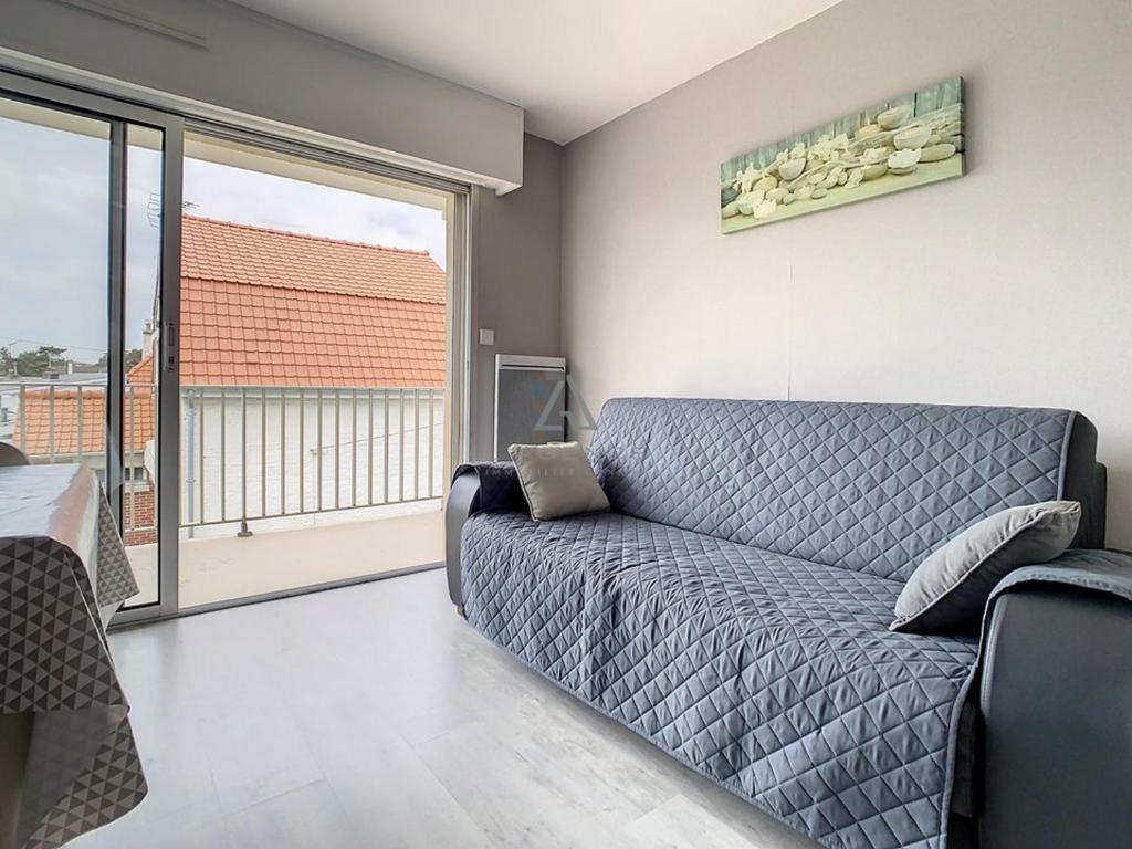 a living room with a couch and a large window at Studio Cucq-Stella Plage, 1 pièce, 2 personnes - FR-1-236-84 in Stella-Plage