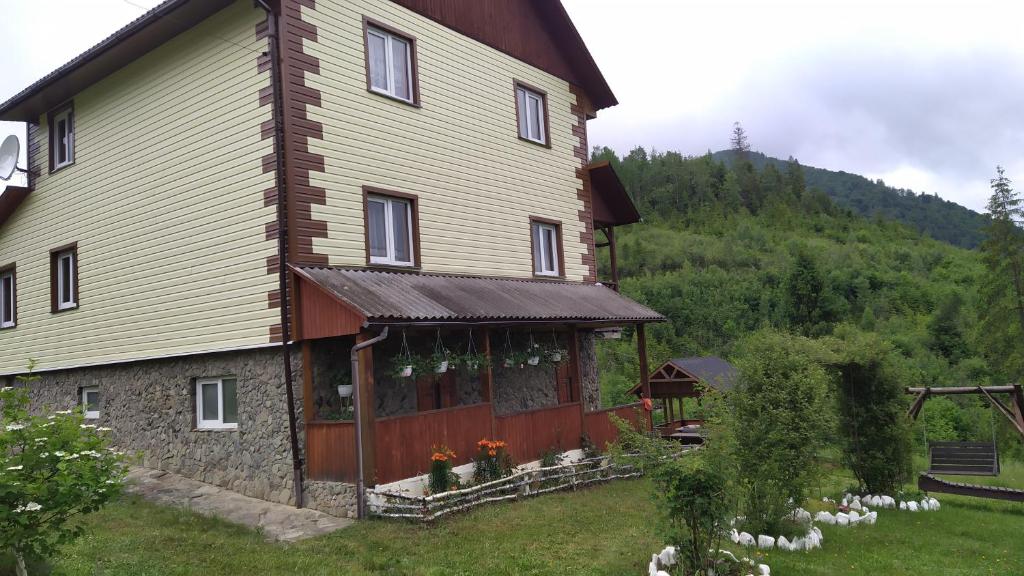una grande casa con un portico su una collina di Родинна оселя a Slavske