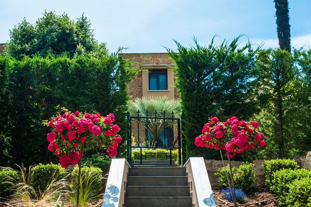 una puerta en un jardín con flores rosas en Azalea Villa Sani, Sani Luxury Villas Collection en Sani Beach
