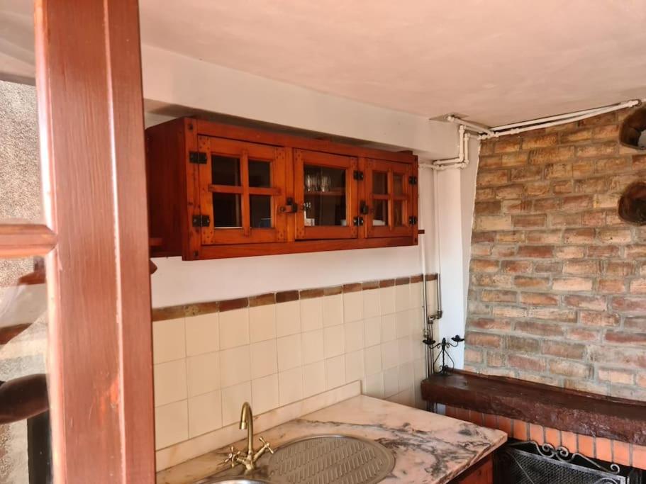 a bathroom with a sink and a brick wall at Casa da Portela in Penacova