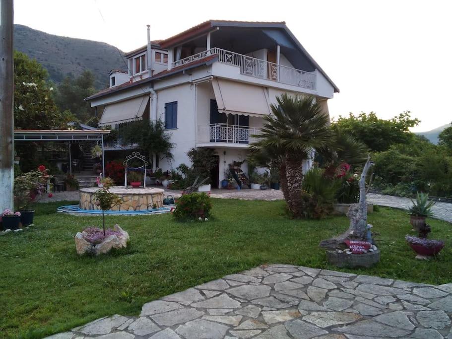 a large white house with a palm tree in a yard at Villa Ylagiali in Plataria
