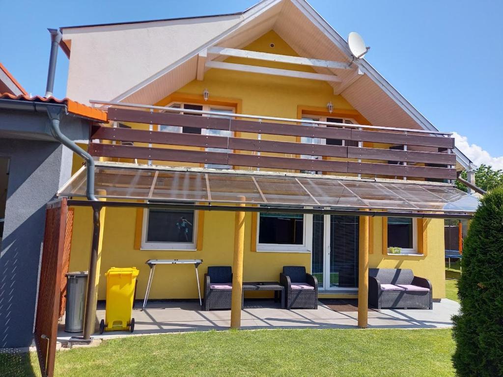 a yellow house with a deck on a patio at Chalupa Liptovský Mikuláš in Liptovský Mikuláš