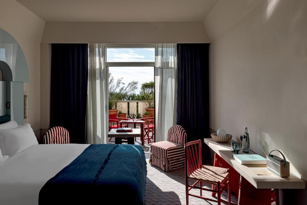 a hotel room with a bed and a table and chairs at Regina Experimental Biarritz in Biarritz