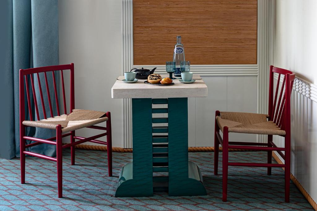 a table and two chairs in a room with a table at Regina Experimental Biarritz in Biarritz