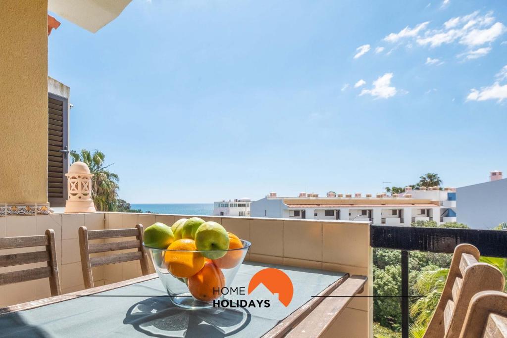 a bowl of fruit sitting on a table on a balcony at #006 Foxy D by Home Holidays in Caliços