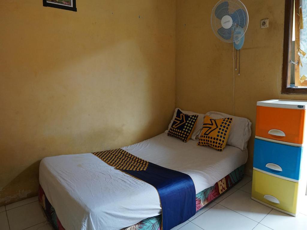 1 dormitorio pequeño con 1 cama y ventilador en SPOT ON 92666 Rumah Kos Arafah Syariah, en Probolinggo