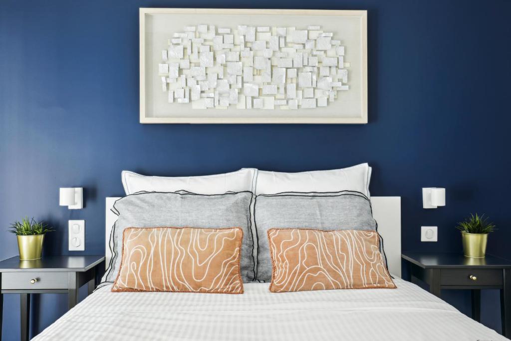 1 Schlafzimmer mit blauen Wänden und 1 Bett mit 2 Kissen in der Unterkunft Dulong - Luxury near Monceau & Wagram in Paris
