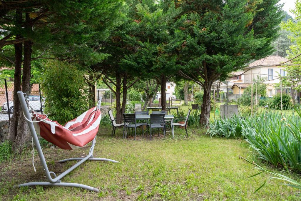 une chaise rouge dans une cour avec une table et des chaises dans l'établissement Alexandra Apartments, à Digne-Les-Bains
