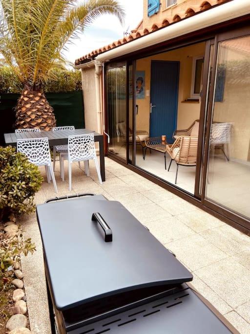 un ordinateur portable assis sur une table sur une terrasse dans l'établissement Villa N°7 à 100m de la plage, à Saint-Cyprien