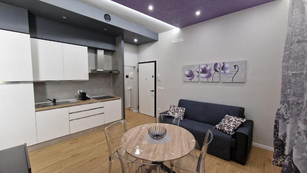 a kitchen and a living room with a table and a couch at CASA FORTUNATO in Bologna