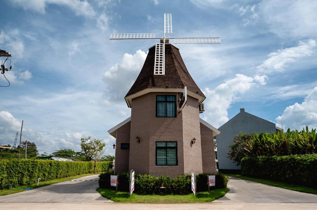 a small house with a windmill on top of it at Crystal Hotel โรงแรมคริสตัล in Ban Nong Wa