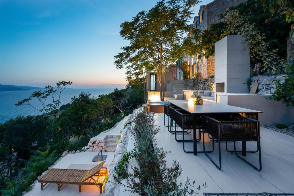 une terrasse avec une table et des chaises et l'océan dans l'établissement Murvica resport, à Murvica