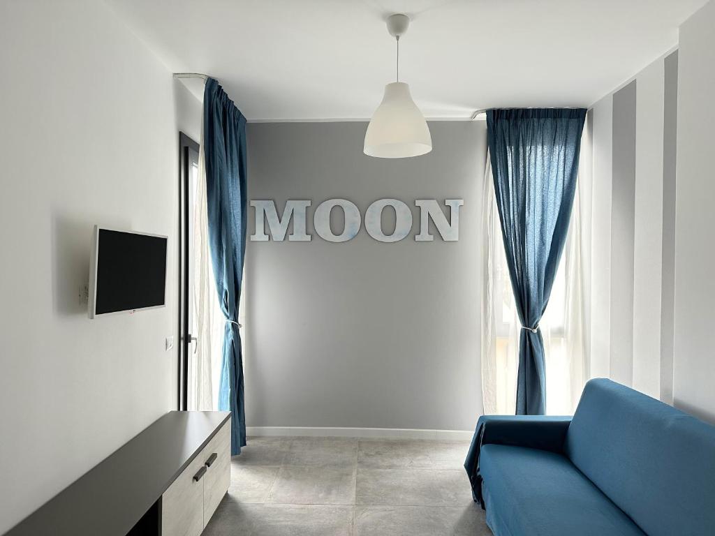 a living room with a blue couch and a window at LUX apartments in Follonica