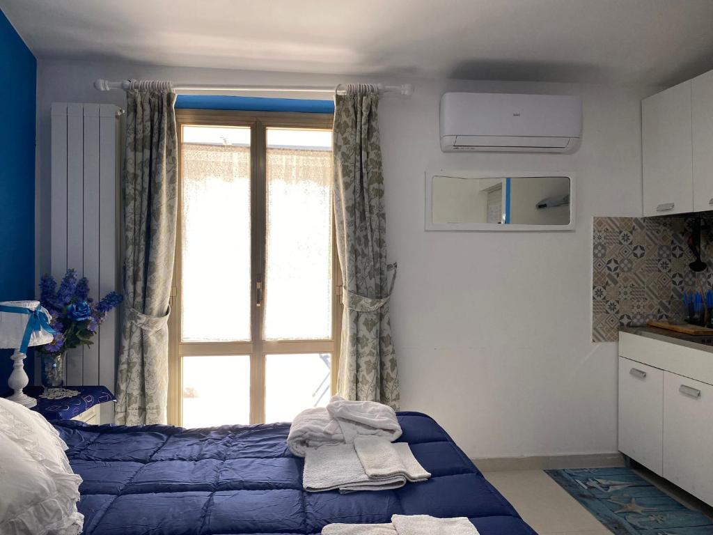 Un dormitorio con una cama azul y una ventana en Pousada Copacabana Praia - AFFITTACAMERE - Casa Vacanza a Porto Sant'Elpidio en Porto SantʼElpidio