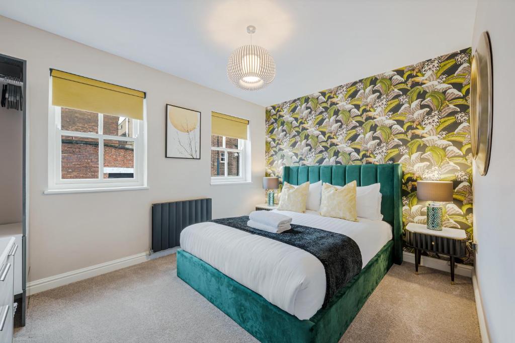 a bedroom with a large bed with a green headboard at Host & Stay - The Pilgrim Coach Houses in Liverpool